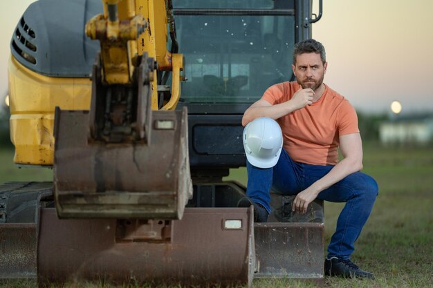builder-with-excavator-construction-construction-site-machinery-tractor-with-builder-buildings-background-excavator-builder-worker-builder-with-helmet-construction-site_545934-55797 builder-with-excavator-construction-construction-site-machinery-tractor-with-builder-buildings-background-excavator-builder-worker-builder-with-helmet-construction-site_545934-55797